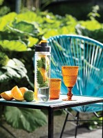Botella grande con boquilla e infusor de fruta color naranja vista de ambiente